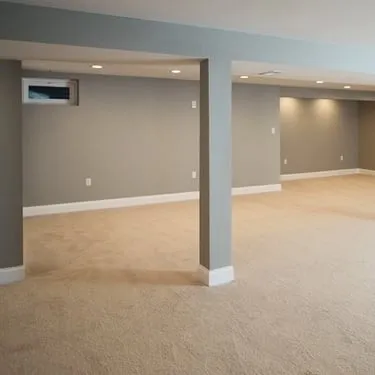 Finished basement with gray walls, carpet, support columns, and recessed lighting