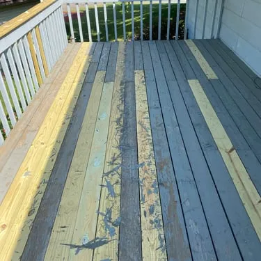 Deck boards being replaced, with fresh and weathered boards visible