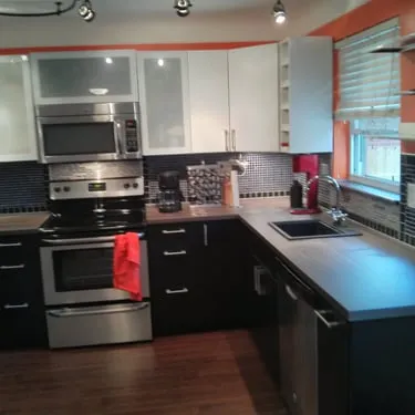 Kitchen with white upper cabinets, dark lower cabinets, and a tiled backsplash
