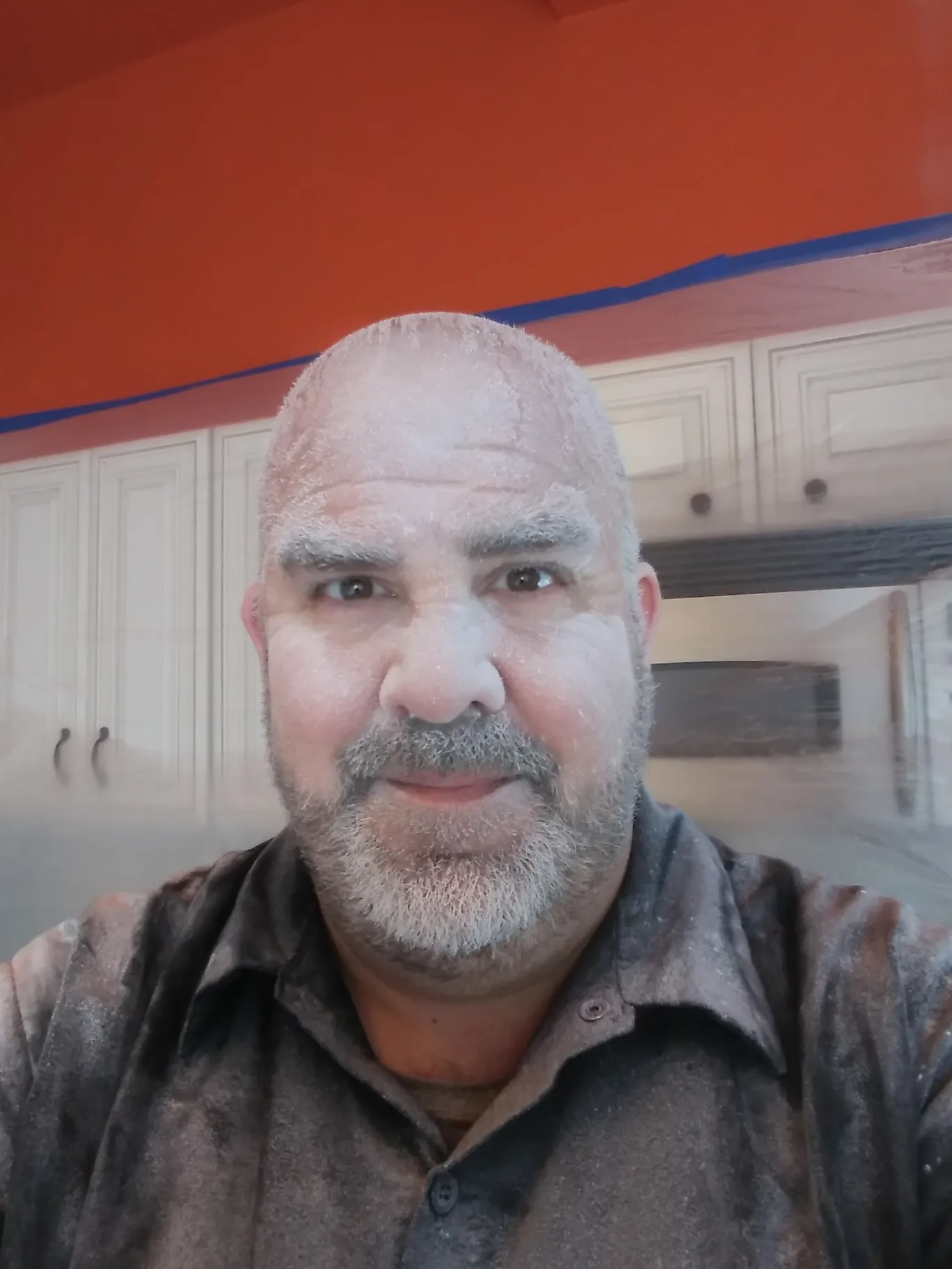 Handyman covered in white dust after drywall work